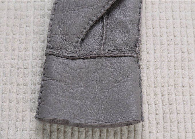 実質の毛皮によって並べられる灰色の最も暖かい羊皮の手袋は指を搭載する表面を滑らかにします
